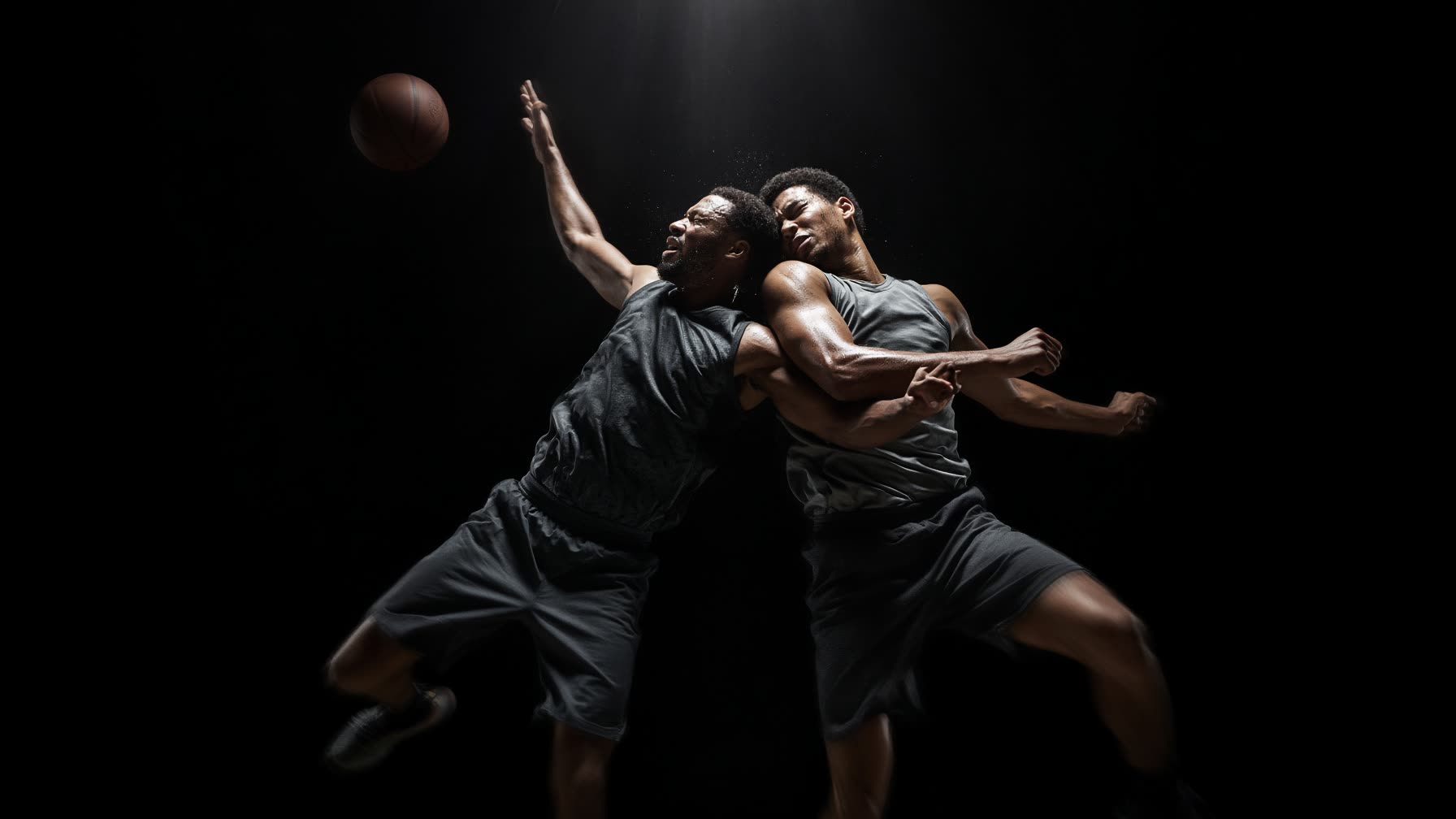 Two basketball players collide going up for the ball.
